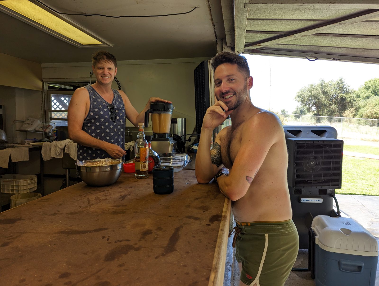 Two campers blending up frozen cocktails at the kitchen bar