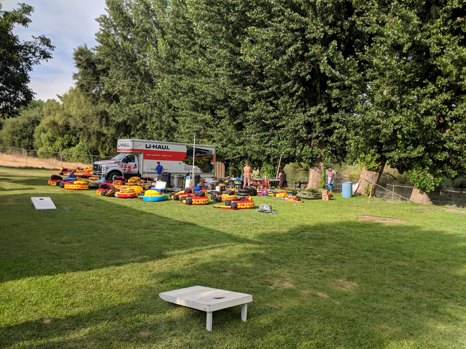 Tubes and cornhole boards laid out on the grass beside the gear truck