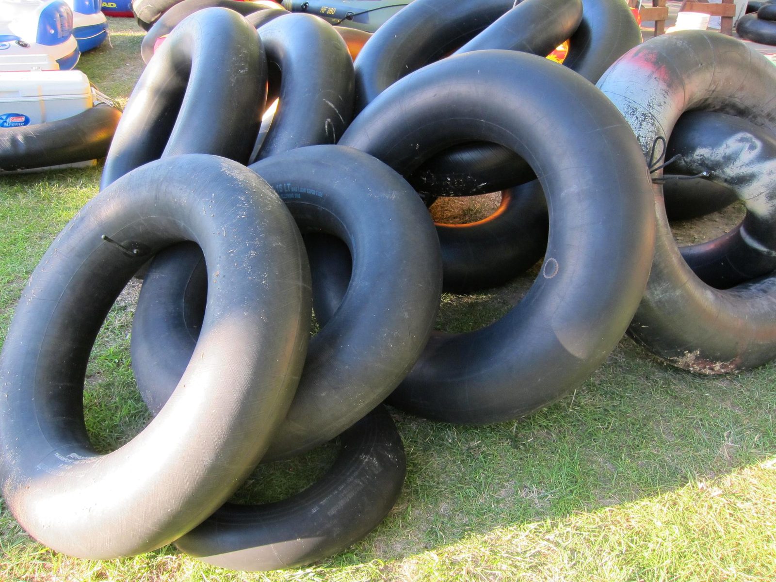 A big pile of inflated inner tubes stacked on the grass